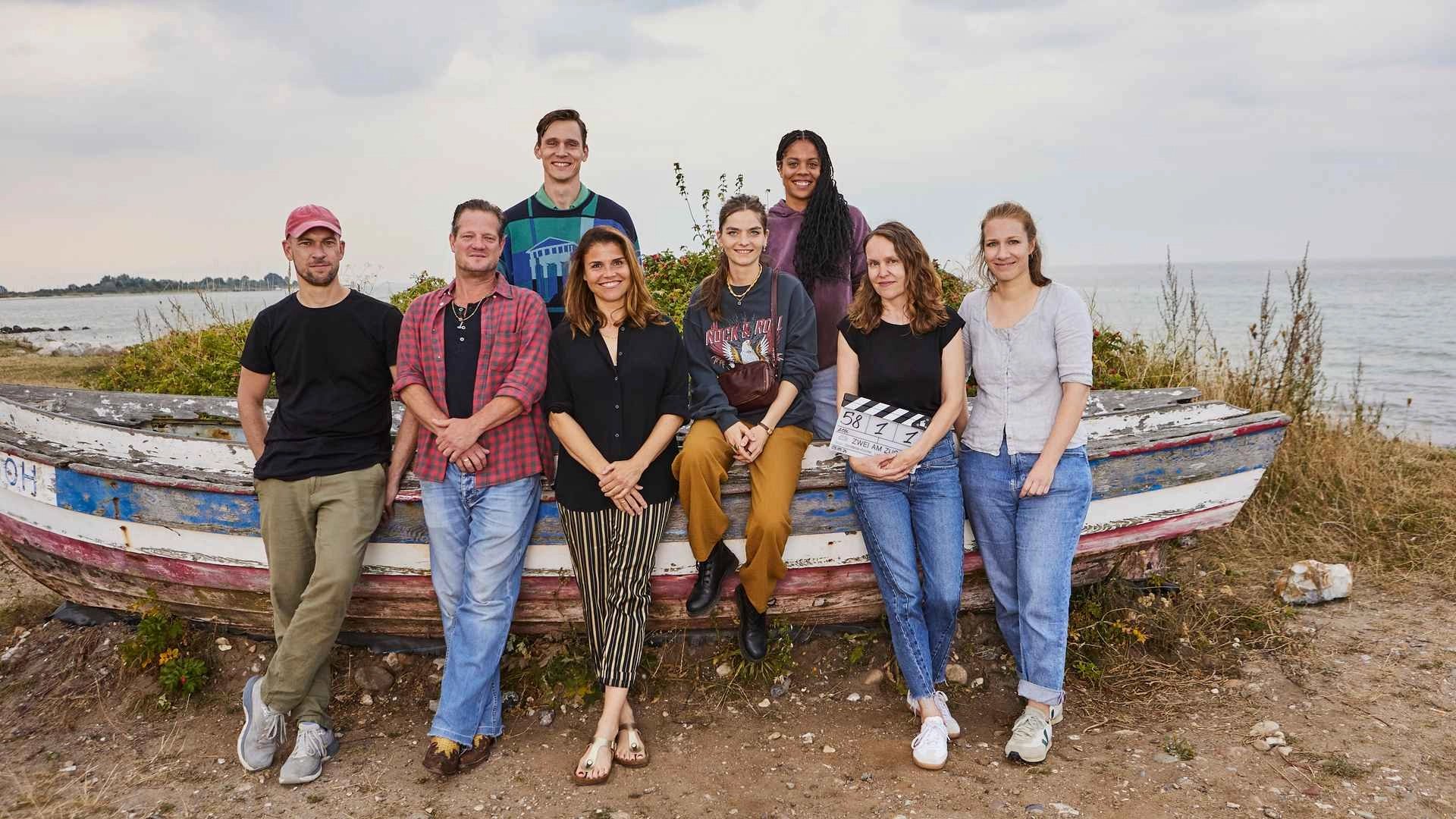 Crew-Foto vor altem, verwitterten Boot an der Ostsee